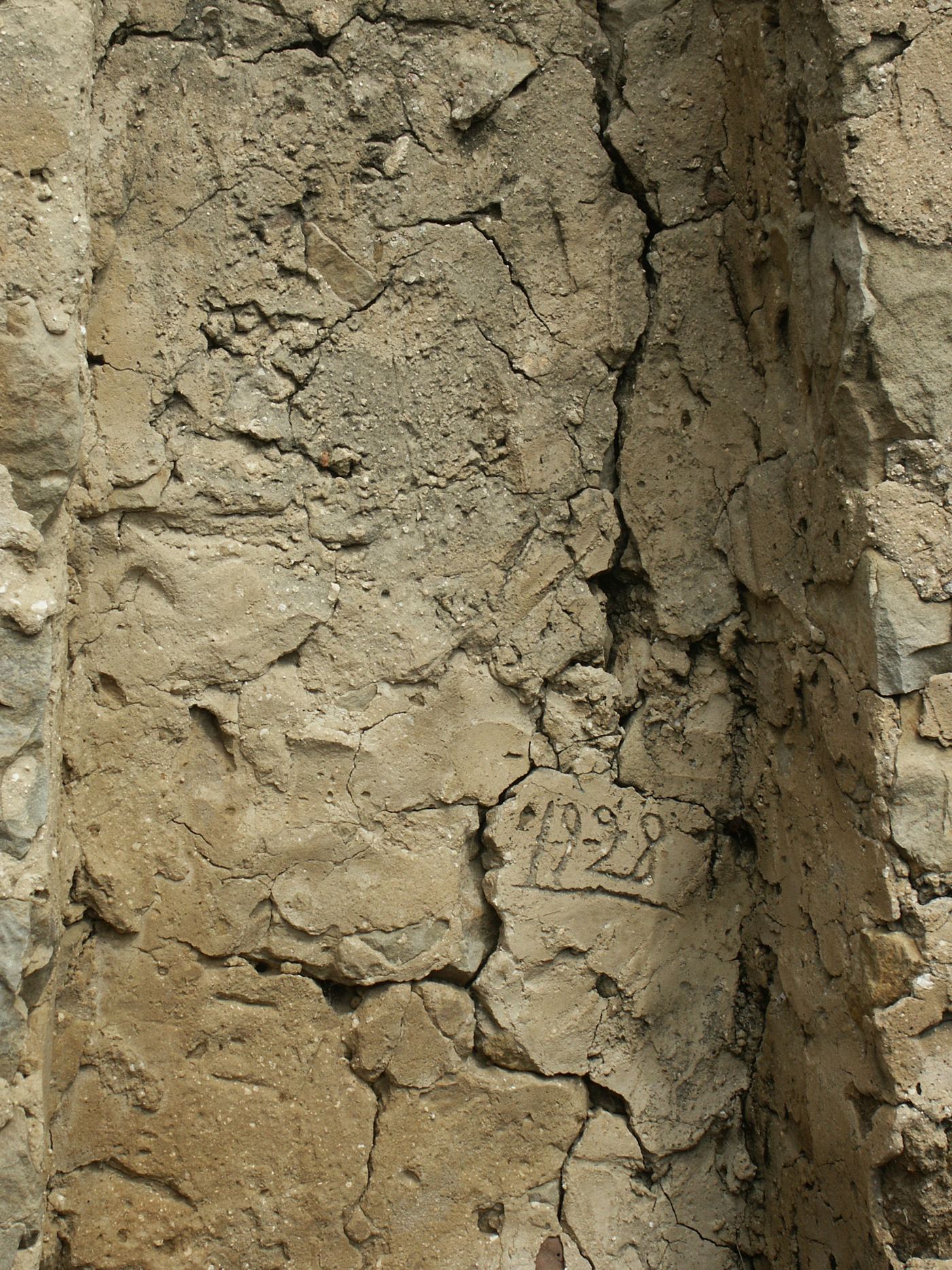 1928, scratched into the render by whoever built the fireplace.