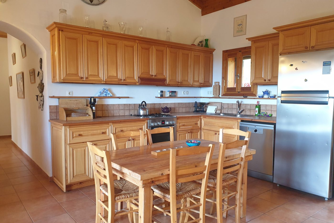 The kitchen at The Olive Farm, with wooden cabinets and the dining table.