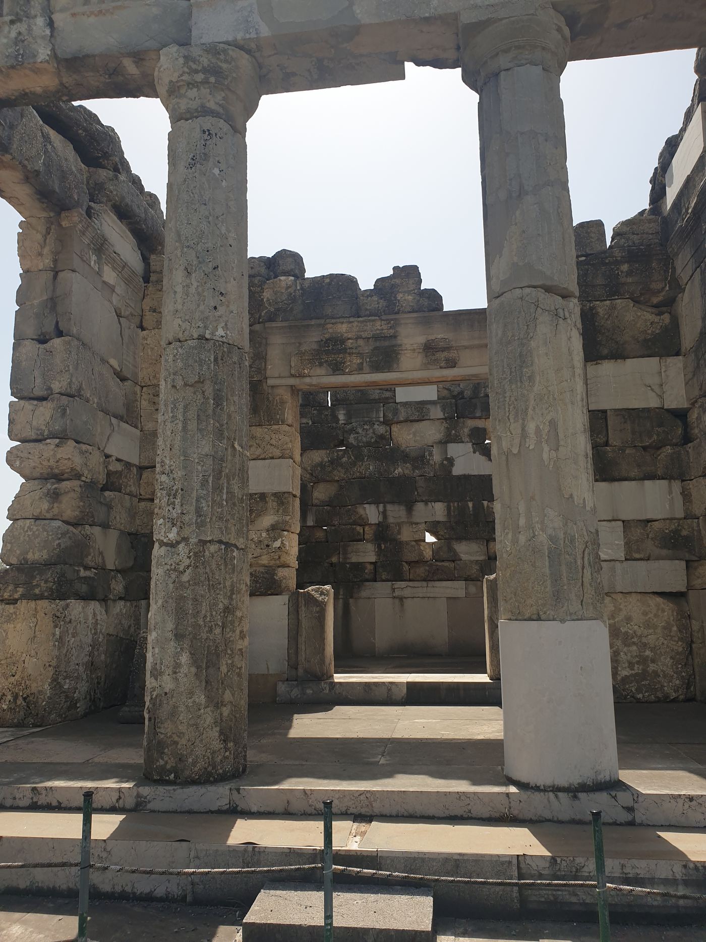 Two columns, with a walled room behind them.
