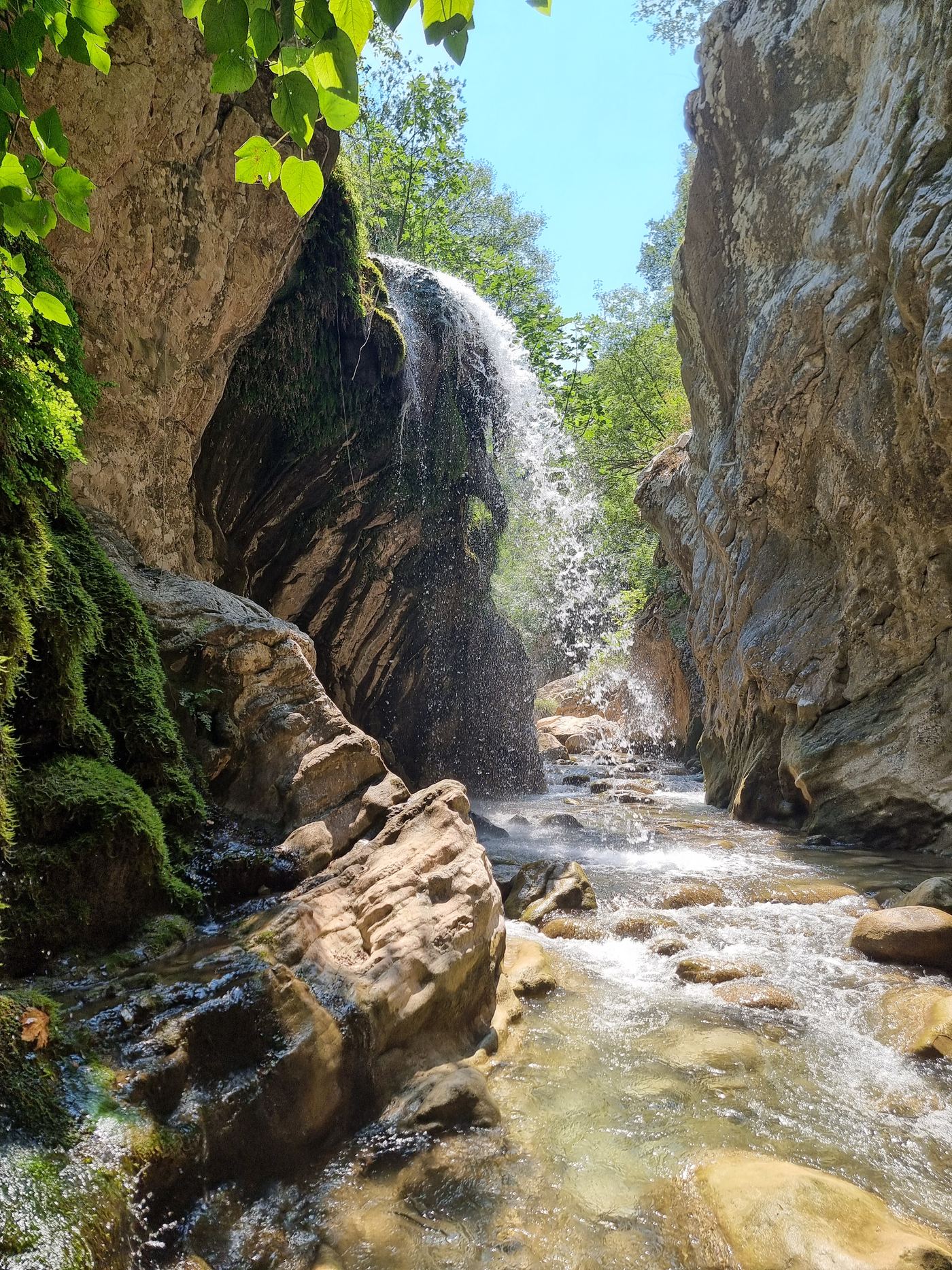 A stream falls vertically into the river below.