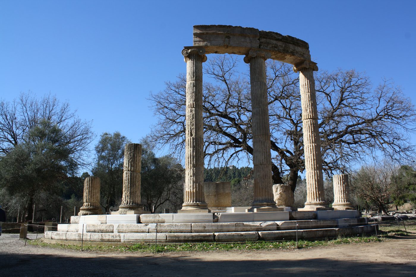 The temple of Hera at Ancient Olympia, with its columns standing against a blue sky.